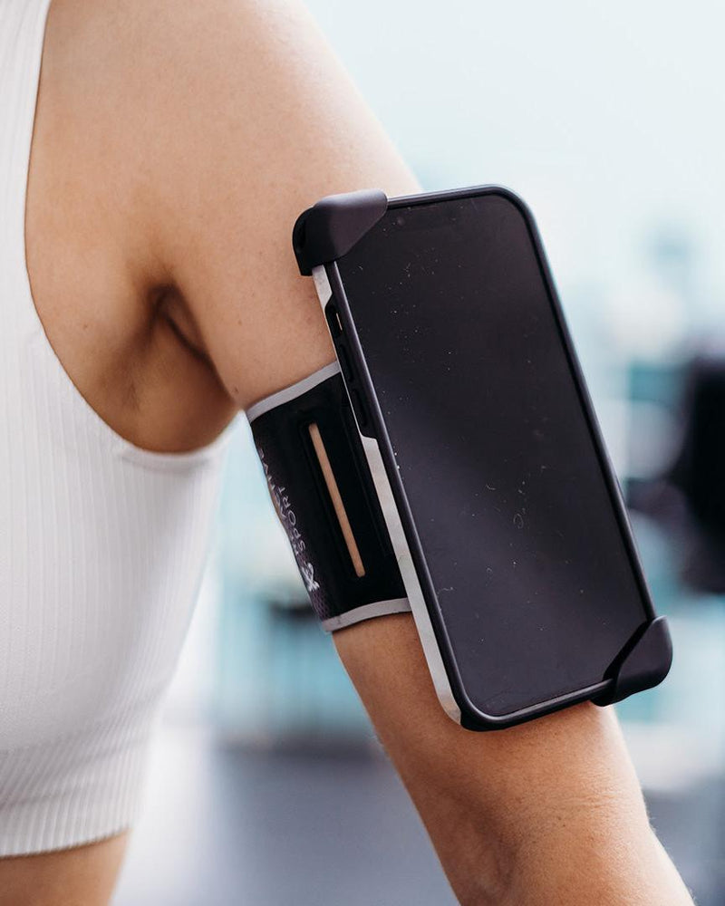 Black Re-Active Sport Phone Holder armband on an arm, securing a smartphone with full screen access.